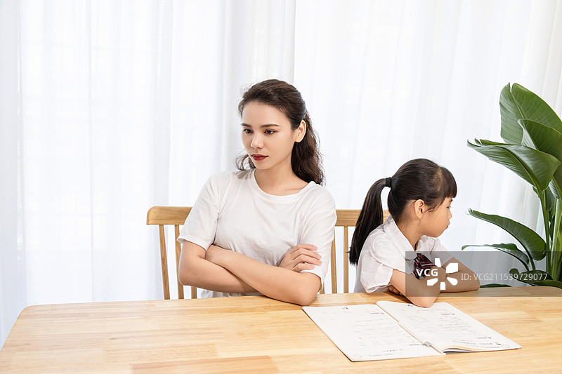 一名妈妈辅导孩子写作业时很苦恼图片素材