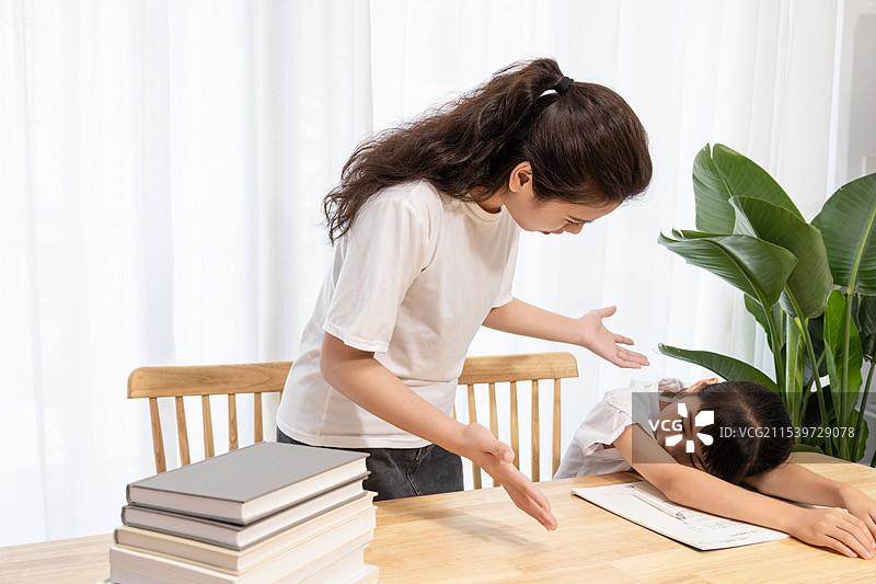 一名妈妈辅导孩子写作业时很苦恼图片素材