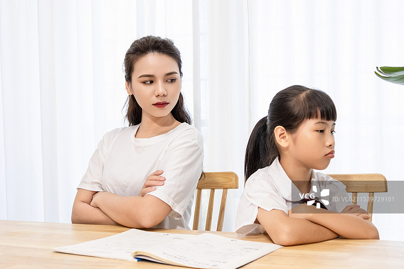 一名妈妈辅导孩子写作业时很苦恼图片素材