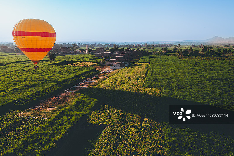 埃及卢克索尼罗河边农田起飞的热气球图片素材