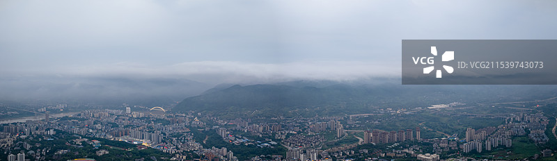 云雾中，航拍山地城市重庆北碚城区城市天际线、城市高楼大厦、车水马龙的交通、远处的高山图片素材