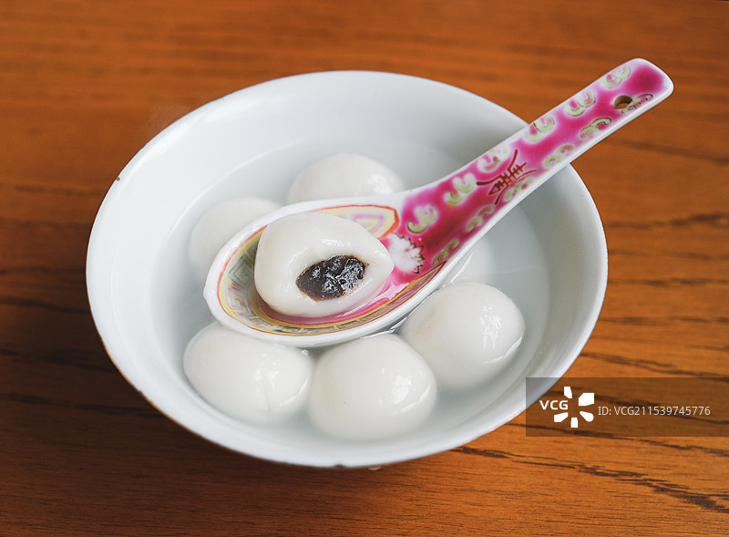 碗中的豆沙汤圆元宵与与一颗咬破的汤团特写图片素材