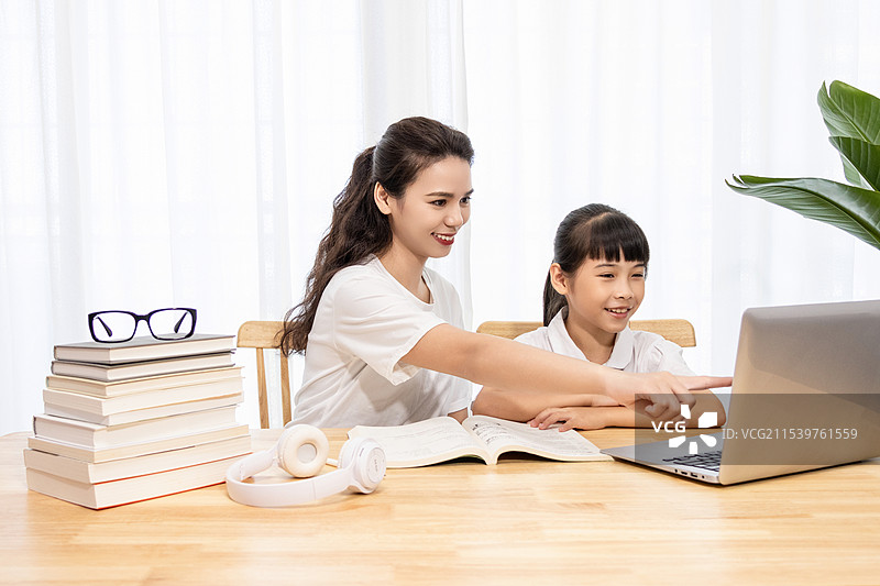 一名妈妈陪伴孩子上网课图片素材