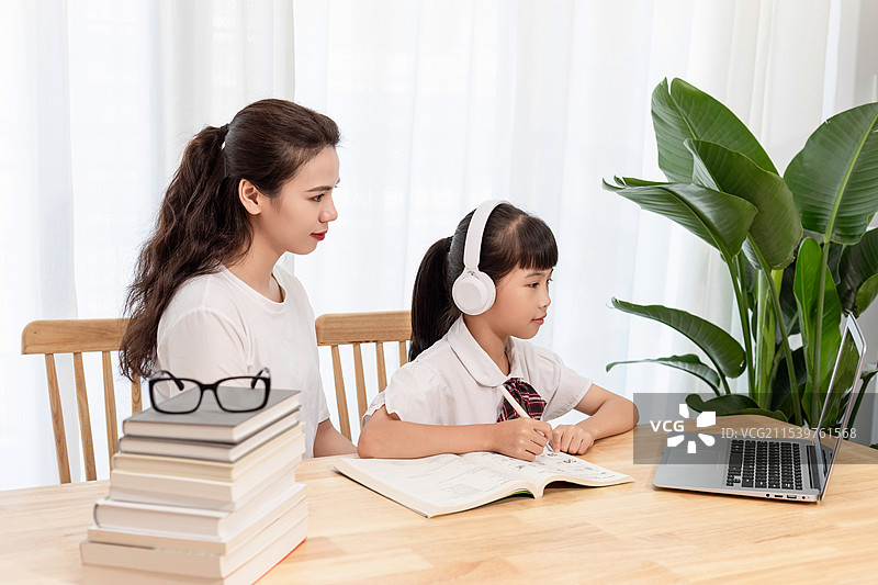 一名妈妈陪伴孩子上网课图片素材