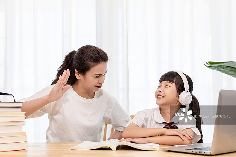 一名妈妈陪伴孩子上网课图片素材