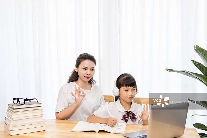 一名妈妈陪伴孩子上网课图片素材