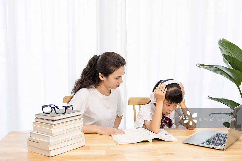 一名妈妈陪伴孩子上网课很疲惫图片素材