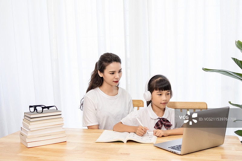 一名妈妈陪伴孩子上网课图片素材
