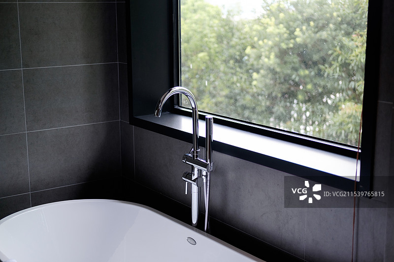 浴室窗边浴缸水龙头特写图片素材