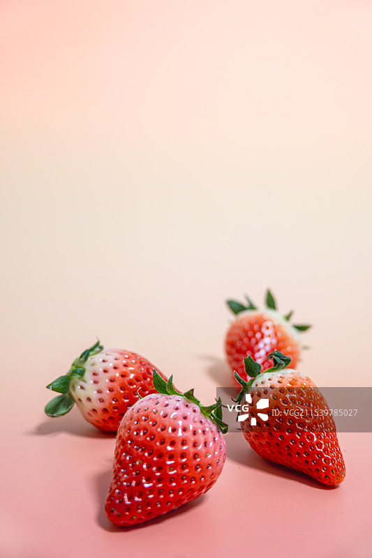 彩色背景下桌子上的草莓的特写镜头，清新留白背景图图片素材