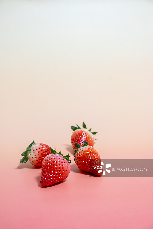 彩色背景下草莓的特写镜头，清新留白背景图图片素材