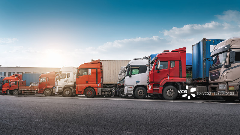 彩色卡车与货运集装箱在公路上排成一行图片素材