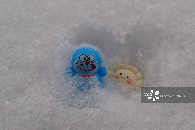 冬天。躲在大雪里的。哆啦A梦和饺子图片素材