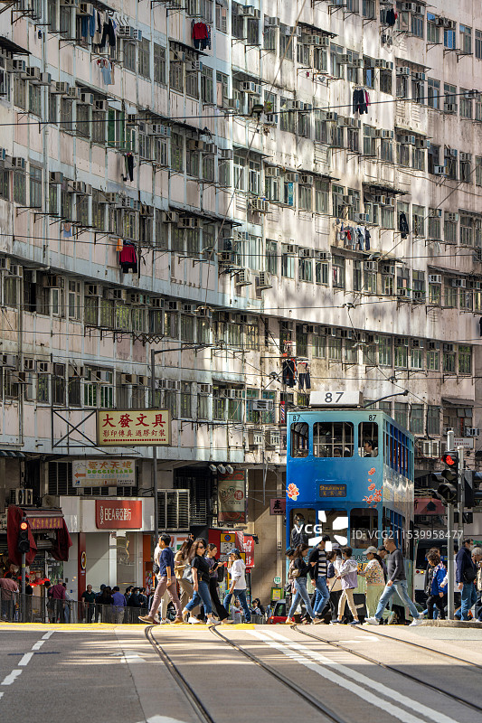 香港密集居民楼、叮叮车和过马路的行人图片素材