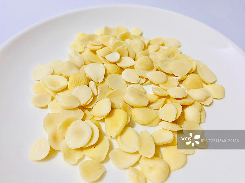 白色背景下盘子里杏仁的特写图片素材