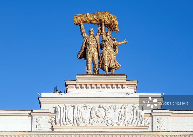 俄罗斯莫斯科全俄展览心中心正门顶端男女社员手举丰收麦穗雕塑，工人与集体农庄女庄员，世界雕塑史杰作图片素材