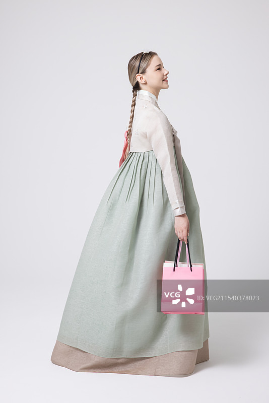 一位西方女性穿着韩服，手里提着购物袋图片素材