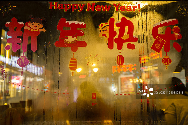 夜晚饭店玻璃上新年快乐的剪纸图片素材