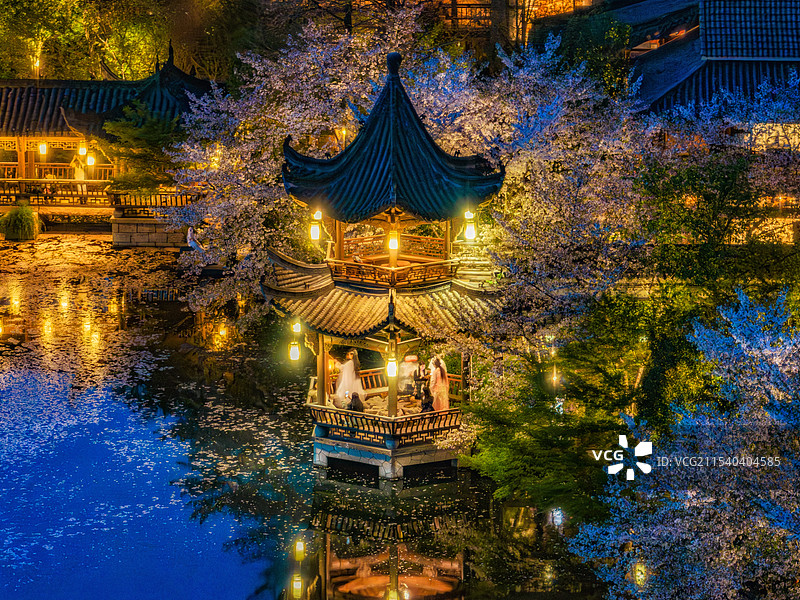 杭州梦溪苑春夜樱花凉亭内身着古装游人图片素材