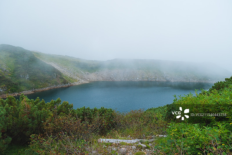 日本富山县立山黑部阿尔卑斯山脉路线室堂云雾中的高原山脉与火山湖图片素材