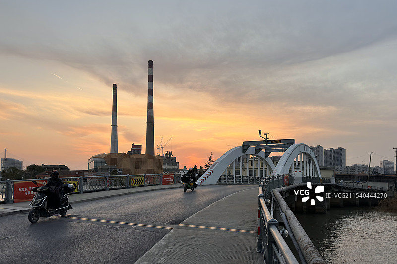 黄昏天空下，上海市复兴岛百年老桥定海路桥，和远处的杨树浦电厂烟囱图片素材