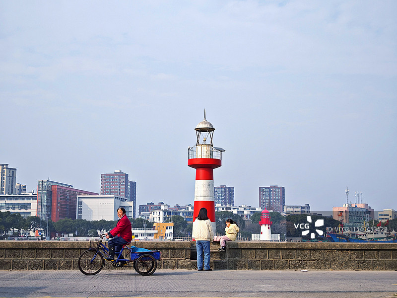灯塔和骑三轮车的老人图片素材