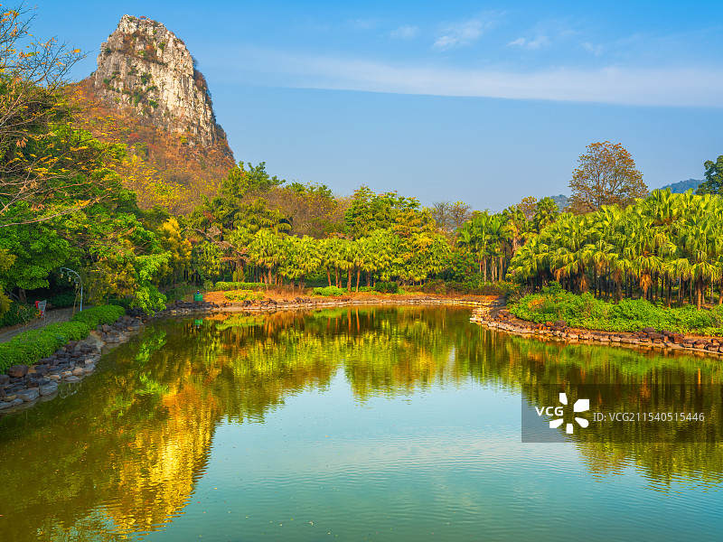 广西柳州马鹿山公园马鹿山、绿树与宁静的湖面反射倒影晴朗天气风光图片素材