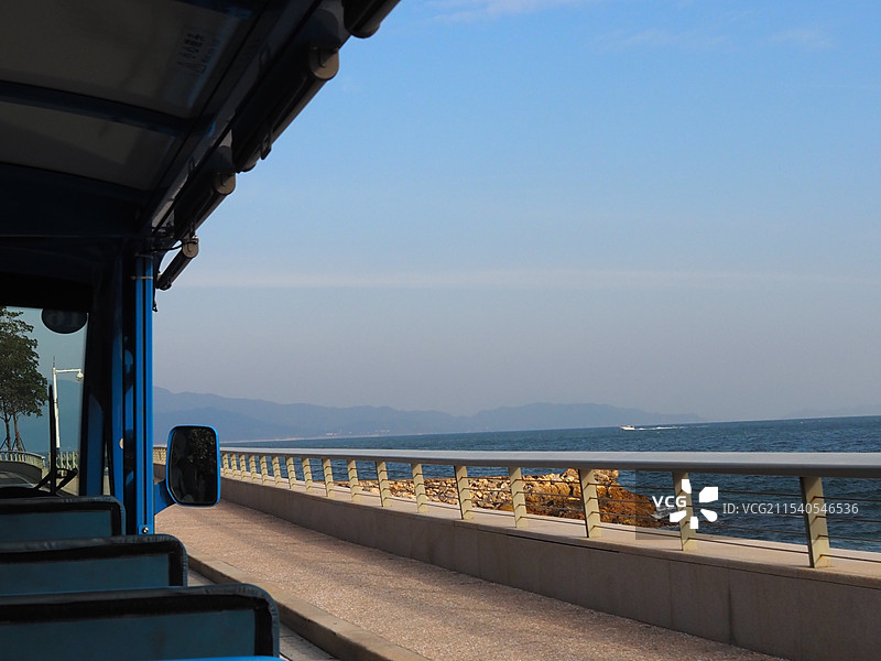 深圳杨梅坑海滨大道景区车角度在清晨的光亮下与远山和蓝色海洋的静谧同框画面图片素材