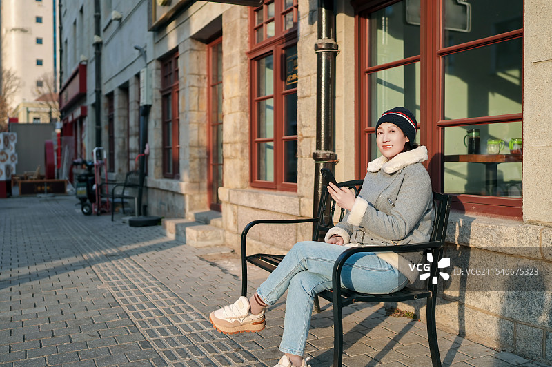 放松的年轻女子在城市环境中享受阳光图片素材