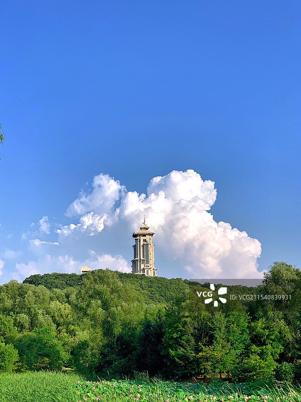 蓝天白云，远处山坡上的建筑物图片素材