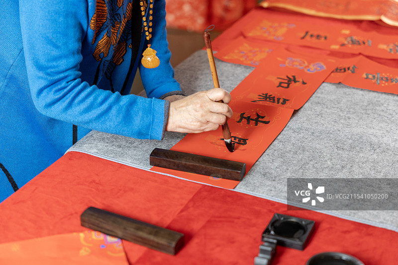 一位女士在用毛笔字写对联图片素材