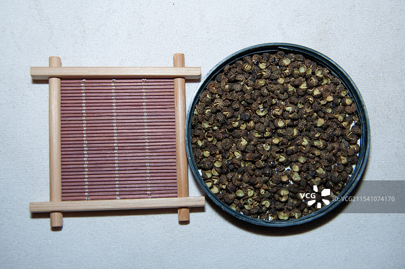 黑色的花椒壳装在瓶盖里图片素材
