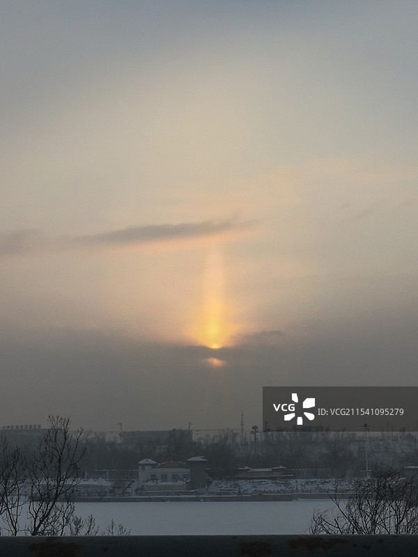 光剑:落日淹没在厚重的云层和雾霾中，一束光芒从云层中垂直穿刺而出，像一把巨大的光剑直插云霄图片素材