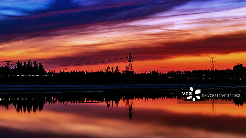 夕阳西下湖边树木的剪影图片素材