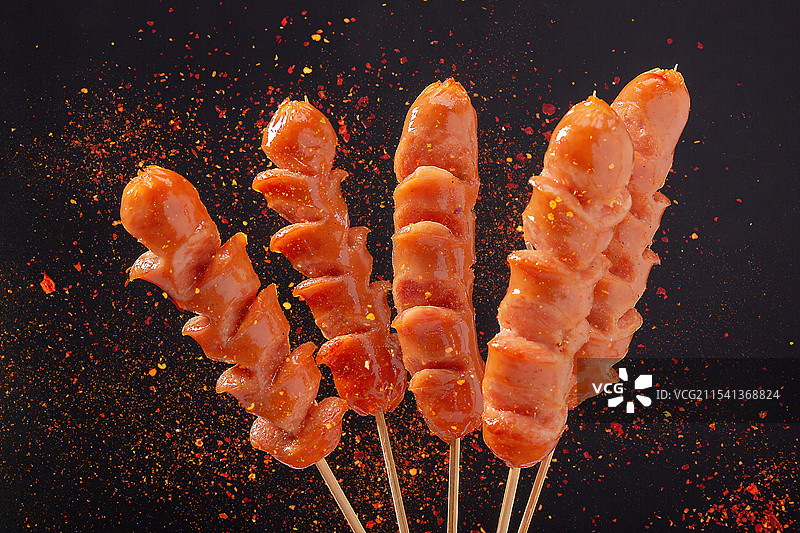 黑色背景前的火山石纯肉烤肠图片素材
