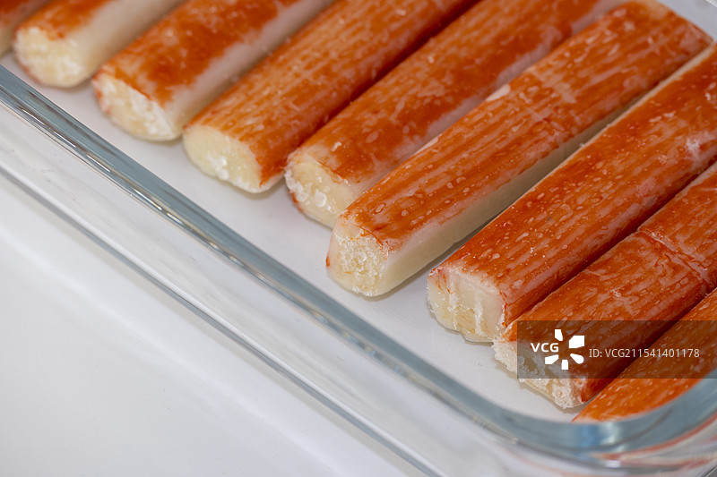 透明烤盘装的一盒冷冻蟹柳特写图片素材
