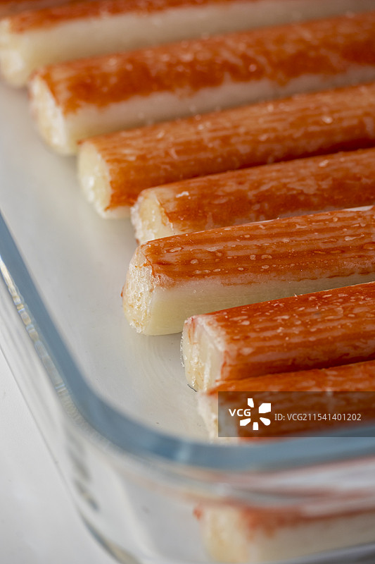 透明烤盘装的一盒冷冻蟹柳特写图片素材