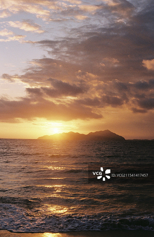海岛日出时海景映衬着戏剧性的天空图片素材