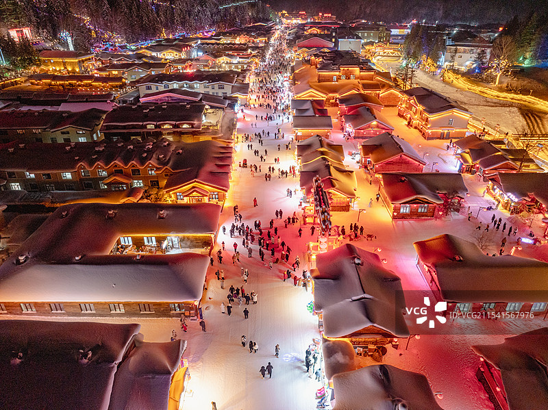 夜晚航拍冬天雪后的中国雪乡夜景，雪韵大街房子彩色灯光迷人图片素材