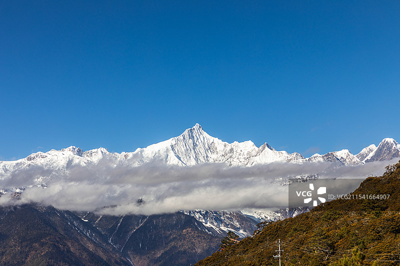 清晨的第一缕阳光照耀云南省德钦县的梅里雪山，日照金山的壮观美景与翻涌的云海呼应，送来一份祝福。图片素材