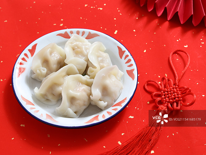 红色背景上的中国传统节日春节年夜饭美食饺子图片素材