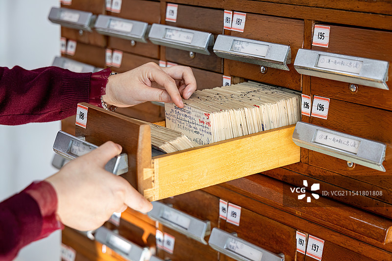在图书馆目录柜查阅图书的女士手部动作图片素材