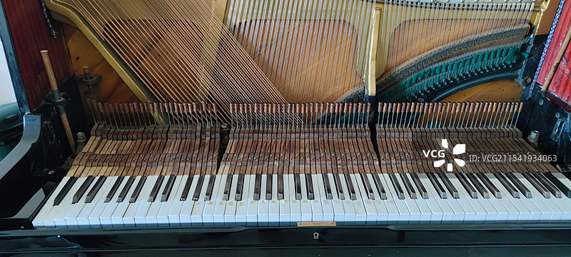 立式钢琴的内部键盘和琴弦排列特写图片素材