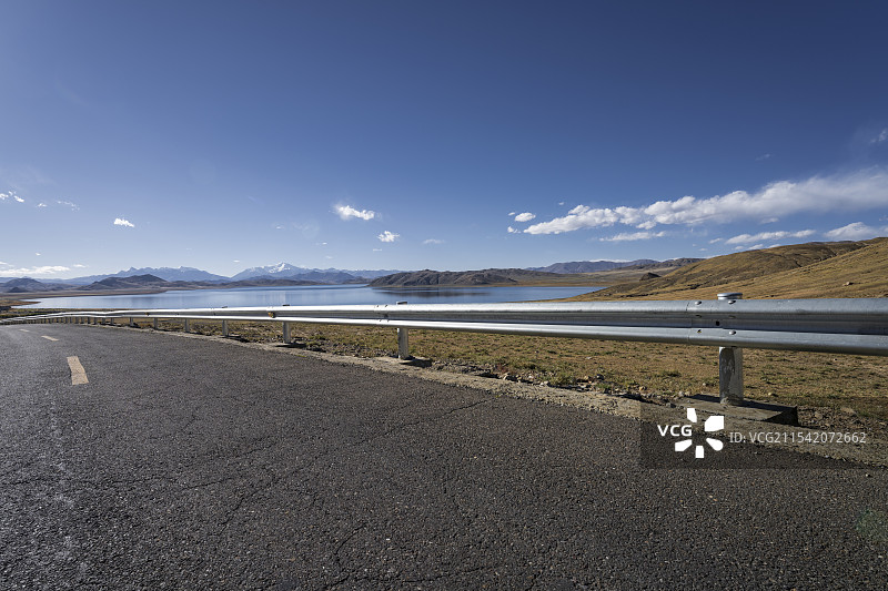汽车广告背景图-蓝天白云下的西藏羊卓雍错道路图片素材