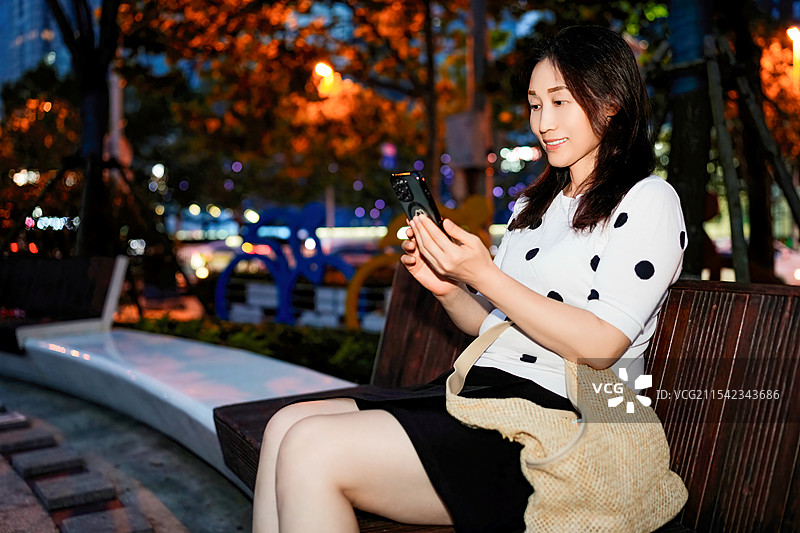 在城市中捕捉夜景自拍的女性图片素材