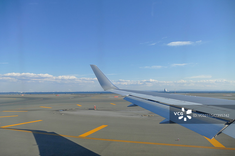 飞机机翼与机场跑道，东京国际机场羽田机场客机在跑道上滑行图片素材
