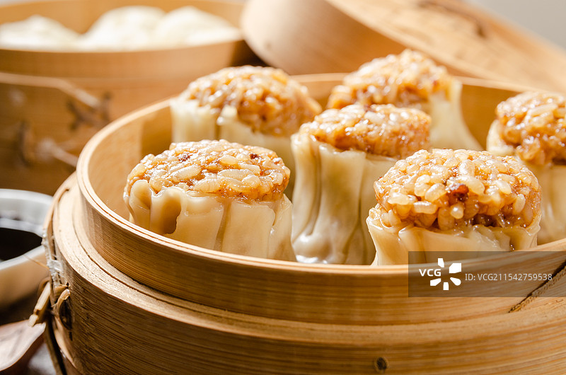 广式早茶点心烧卖放在竹制蒸笼里图片素材