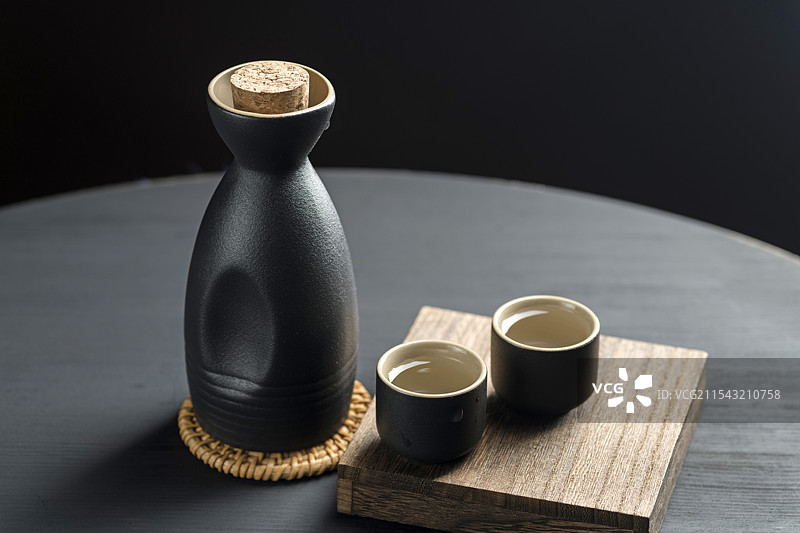 男性手拿酒壶倒酒特写深色调图片素材