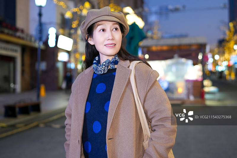 时尚的女人在节日的城市里享受冬夜漫步图片素材