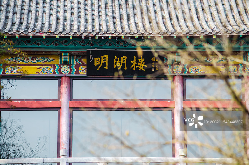 中国5A级旅游景区拍摄主题，山东济南大明湖公园园林，明月楼城楼和前景的树枝，户外白昼无人图像摄影图片素材